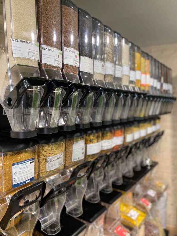 Le mur de distributeurs en vrac du magasin, rempli de céréales et de légumineuses